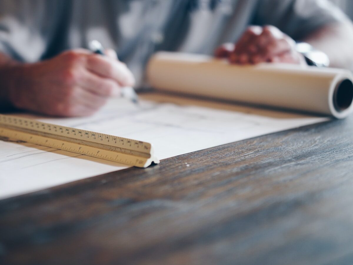 person drafting on blueprint